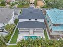 Aerial view of a modern home showcasing a backyard with a swimming pool, lush landscaping, and a spacious patio area at 5017 W Dickens Ave, Tampa, FL 33629
