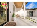 Welcoming front porch features rocking chairs, a tiled walkway, and a modern door with wreath at 5546 Drexel Rd, Land O Lakes, FL 34638