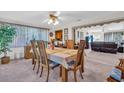 Bright dining room with a wooden table and chairs, open to the living area at 8490 7Th N Ln, St Petersburg, FL 33702