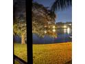 Serene water view with a fountain, lush greenery, and the soft glow of nighttime lighting at 1020 Bowsprit Ln # X, Holiday, FL 34691