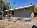 Side view of home with light green siding, yellow trim, and a sturdy brick chimney at 1044 Virginia Dr, Sarasota, FL 34234