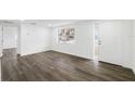 Bright living room with wood-look floors and a glass-paneled front door at 1109 Landau St, Holiday, FL 34690