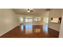 Open-concept living room featuring hardwood floors and large windows offering ample natural light at 11722 Currie Ln # E1, Largo, FL 33774
