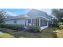 The back exterior of the house features a cozy enclosed porch and neat landscaping at 11722 Currie Ln # E1, Largo, FL 33774