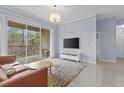 Bright living room featuring a sliding door to the balcony, modern furnishings, and light-colored tile flooring at 17106 Carrington Park Dr # 622, Tampa, FL 33647