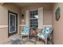 Cozy front porch sitting area with tiled floor, comfortable seating, and decorative outdoor lighting at 2240 Parrot Fish Dr, Holiday, FL 34691