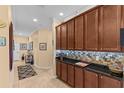 Hallway features dark wood cabinetry, mosaic backsplash, and modern lighting at 2240 Parrot Fish Dr, Holiday, FL 34691
