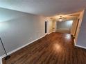 A spacious living room featuring hardwood floors, neutral paint, and an open layout with an adjacent room at 2484 Roberta St, Largo, FL 33771