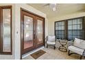 Cozy front porch featuring seating and double front doors leading into the main house at 3462 Sutton Pl, Palm Harbor, FL 34684