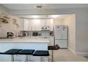 Bright, updated kitchen with white cabinetry, stainless steel appliances, and a breakfast bar at 8413 N Hamner Ave # A, Tampa, FL 33604