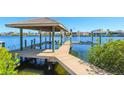 Beautiful covered boat dock featuring a boat lift overlooking the water at 946 Allegro Ln, Apollo Beach, FL 33572