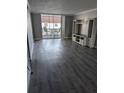 Spacious living room featuring wood flooring, a sliding glass door, and a built in shelving unit at 10530 77Th Ter # 224, Seminole, FL 33772
