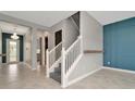 Bright entryway featuring tile flooring and a staircase with white railings at 11724 Sunburst Marble Rd, Riverview, FL 33579