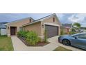 View of a property with manicured landscaping, including a paved walkway and driveway at 13052 Ogden Glade Rd, Dade City, FL 33525