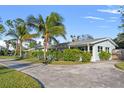 Well-maintained single-story home with a large driveway, green lawn, and mature landscaping including palms at 1500 Carson Ne Cir, St Petersburg, FL 33703