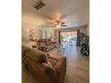 Comfortable living room featuring modern flooring, ceiling fan, and sliding glass doors at 19029 Us Highway 19 N # 12E, Clearwater, FL 33764