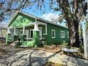 Green home with a charming front porch and lush landscaping at 2410 Harper St, Tampa, FL 33605