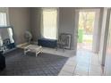 Cozy living room featuring an area rug, window, and doorway leading outside at 2410 Harper St, Tampa, FL 33605