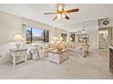Bright living room featuring a ceiling fan, a large window and a mirror wall for enhanced spaciousness at 2576 Laurelwood Dr # 13C, Clearwater, FL 33763