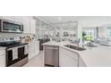 Bright, modern kitchen featuring stainless steel appliances and a large island with a sink at 31570 Ancient Sage Rd, Wesley Chapel, FL 33545