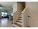 Staircase view that leads into the living room and kitchen area with tiled floors at 34110 Jasper Stone Dr, Wesley Chapel, FL 33543