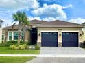 Beautiful single-story home showcasing a well-manicured lawn and three-car garage and detailed roof at 3444 Acacia Bay Ave, Wesley Chapel, FL 33543