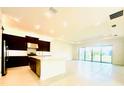 Bright, open kitchen and living area with stainless appliances, a kitchen island, and sliding glass doors at 3444 Acacia Bay Ave, Wesley Chapel, FL 33543