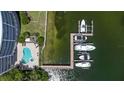 Aerial view of community amenities: pool and a boat dock with multiple boat slips on a sunny day at 3805 Gulf Blvd # 404, St Pete Beach, FL 33706