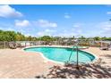 Community pool with a separate jacuzzi area overlooking the bay, complete with brick pavers and lounge chairs at 3805 Gulf Blvd # 404, St Pete Beach, FL 33706