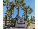 Coquina Key entrance with tropical landscaping and a welcoming sign at 4401 Neptune Se Dr, St Petersburg, FL 33705