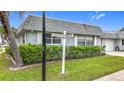 Corner lot featuring a cozy home with tidy landscaping and a street marker indicating the address at 504 Cara Ct # 504, Largo, FL 33771
