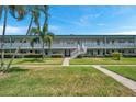Exterior shot showing a 2-story condo building with palm trees and well-manicured lawns at 5267 81St N St # 18, St Petersburg, FL 33709
