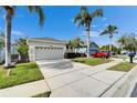 Beautiful single-story home featuring a two-car garage, well-kept lawn, and mature palm trees at 8141 Ambersweet Pl, Land O Lakes, FL 34637