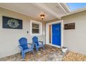 Inviting front porch featuring blue Adirondack chairs and a brightly colored front door at 8448 Flagstone Dr, Tampa, FL 33615