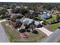 Well-maintained home with mature landscaping, a screened lanai, and a brick paver driveway at 10302 Belltower St, Spring Hill, FL 34608