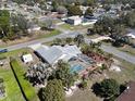 Spacious home with a screened-in pool, mature palm trees, and lush green landscaping at 10302 Belltower St, Spring Hill, FL 34608