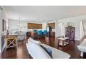 Spacious open-concept living area with hardwood floors and a modern kitchen in the background at 10642 Mistflower Ln, Tampa, FL 33647