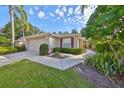 Home exterior with a walkway leading to the front door, surrounded by lush greenery at 1171 Corinth Greens Dr, Sun City Center, FL 33573