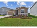 Charming single-Gathering home featuring a well-manicured lawn and a two-car garage at 1409 Tropical Oasis Ave, Plant City, FL 33565