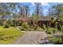 Inviting home featuring a walkway leading to the front door, surrounded by verdant landscaping and greenery at 17119 Rainbow Ter, Odessa, FL 33556