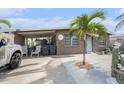 Single story home with a covered carport, featuring stone accents, a white front door, and a tropical palm tree at 265 115Th Ave, Treasure Island, FL 33706