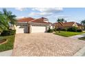 Well-maintained three-car garage with a lush, landscaped yard at 2769 Harvest Drive, Sarasota, FL 34240