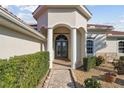 Home's elegant front entrance with pillars and a beautifully tiled walkway at 2769 Harvest Drive, Sarasota, FL 34240