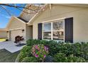 Close up of a charming home features beautiful landscaping, large window, two-car garage, and a welcoming entryway at 36707 Goffaux Loop, Zephyrhills, FL 33541