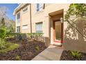 Inviting front entry with a red door, lush landscaping, and a well-maintained walkway at 4216 Preserve Pl, Palm Harbor, FL 34685