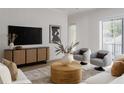 Bright living room with sleek console, modern art, and cozy seating area at 440 Capri Ne Way, St Petersburg, FL 33704