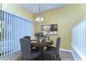 Cozy dining room featuring a round wood table set for four, complemented by modern lighting and soft window light at 6255 Osprey Lake Cir, Riverview, FL 33578