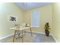 Bright home office space features a minimalist glass desk, comfortable chair, and ample natural light from a window at 6255 Osprey Lake Cir, Riverview, FL 33578