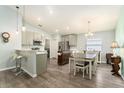 Open-concept kitchen and dining area with stainless steel appliances, island, and modern finishes at 6863 Hanworth Ln, Zephyrhills, FL 33541