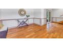 Sunlit foyer with decorative table, mirror and glass paneled door, complemented by stylish wood flooring at 73 Sunset Ln, Terra Ceia, FL 34250